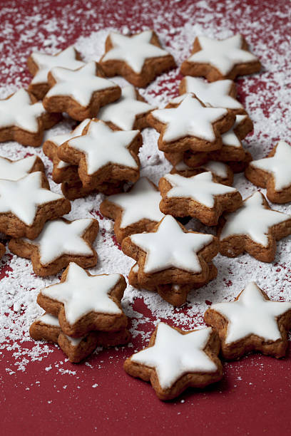 Cinnamon stars sprinkled with powder sugar on red background