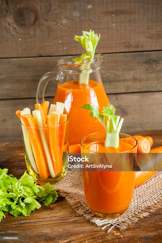 Fresh carrot juice with carrots and celery Fresh carrot juice with carrots and celery on dark wooden background Carrot Juice Stock Photo