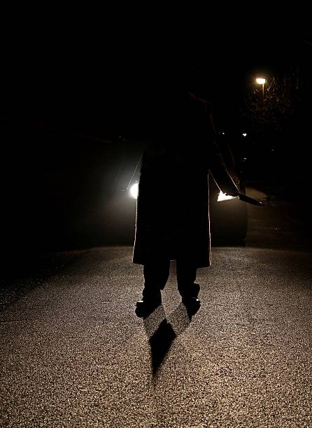 istock sinister figure in front of car headlights 518627000