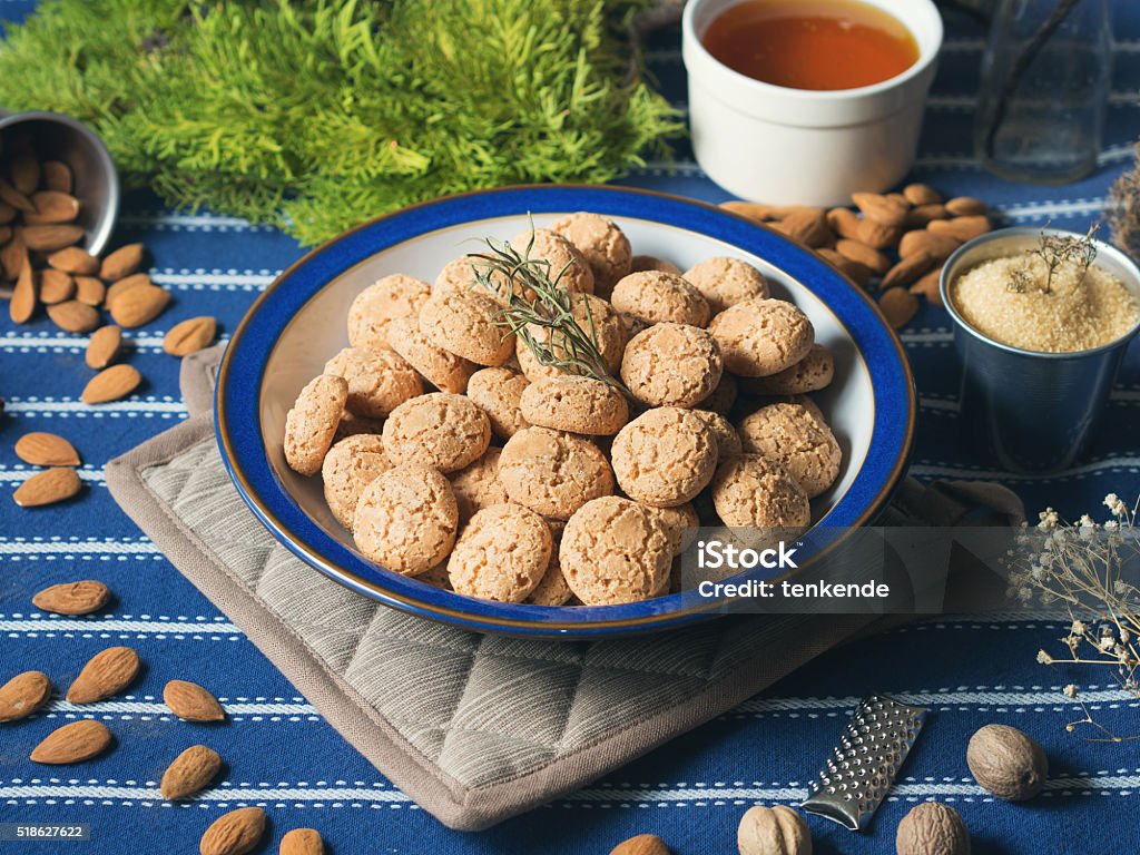 Amaretti biscuits Heap of amaretti almond biscuits in a plate on dark blue table cloth, winter food still life Almond Stock Photo