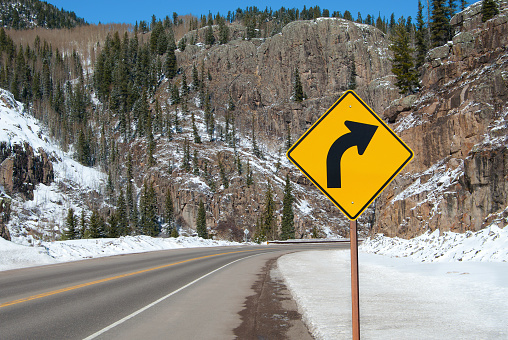 A sign warns of a right turn ahead on a mountain road in southern Colorado.