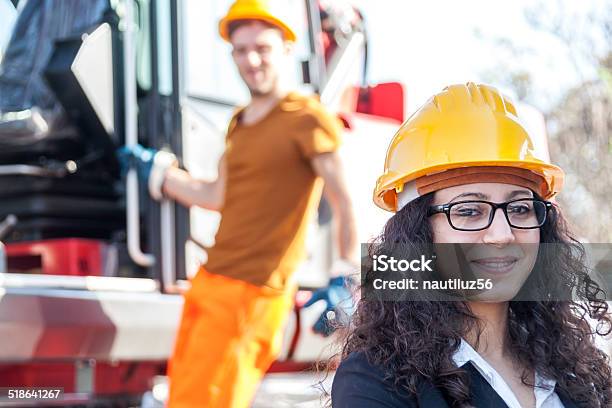 Young Female Engineer Posing In Junkyard With A Worker Stock Photo - Download Image Now