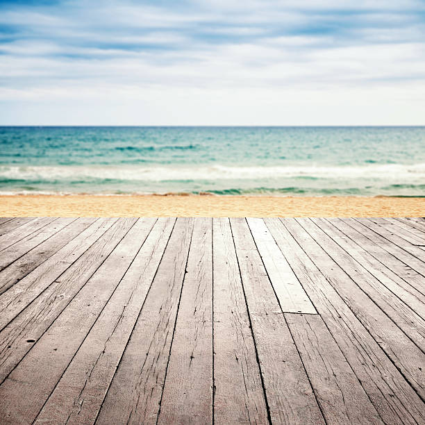istock Old empty wooden pier perspective on sandy beach 518648282