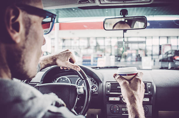 istock Man driving his Car and drinking take away coffee 518648886