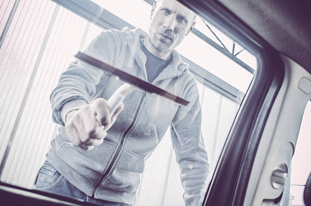istock Man washing his car - drying windows 518649070