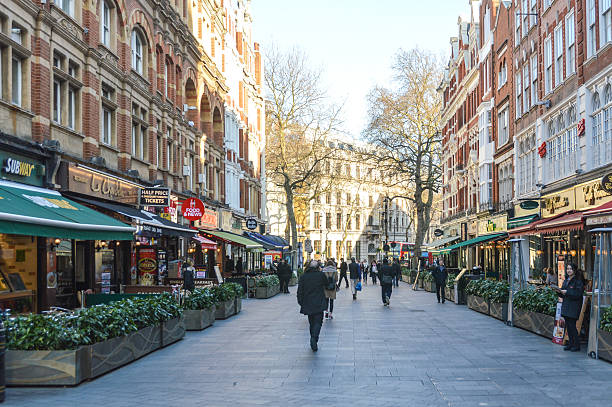 The colorful streets of London London, UK - March 15, 2016: The streets of London. Photo taken during a cold spring day. There are people walking the street and many business storefronts seen in the photo. harrods photos stock pictures, royalty-free photos & images