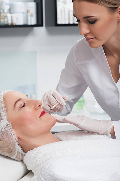 istock Professional young cosmetologist is treating her patient 518653182