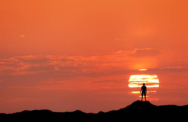 istock Sunset landscape with silhouette of a man 518654120