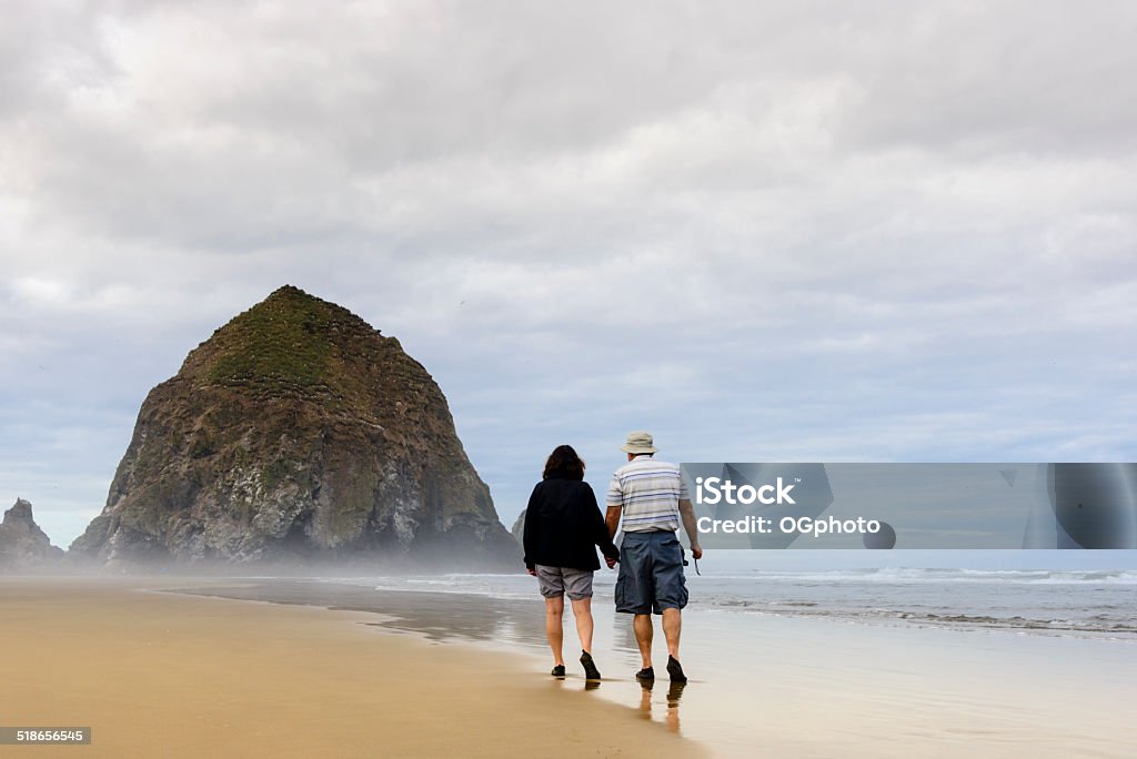 XXXL: Mature couple walking on the beach Mature couple holding hands walking on the beach.  Cannon Beach, Oregon Mature Women Stock Photo