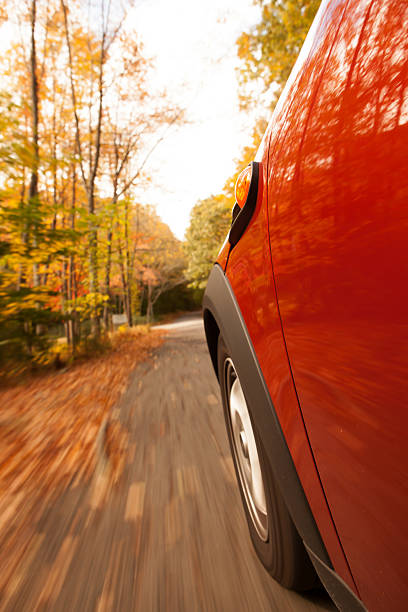 istock Sports car speeding along a tree lined road in fall 518657491