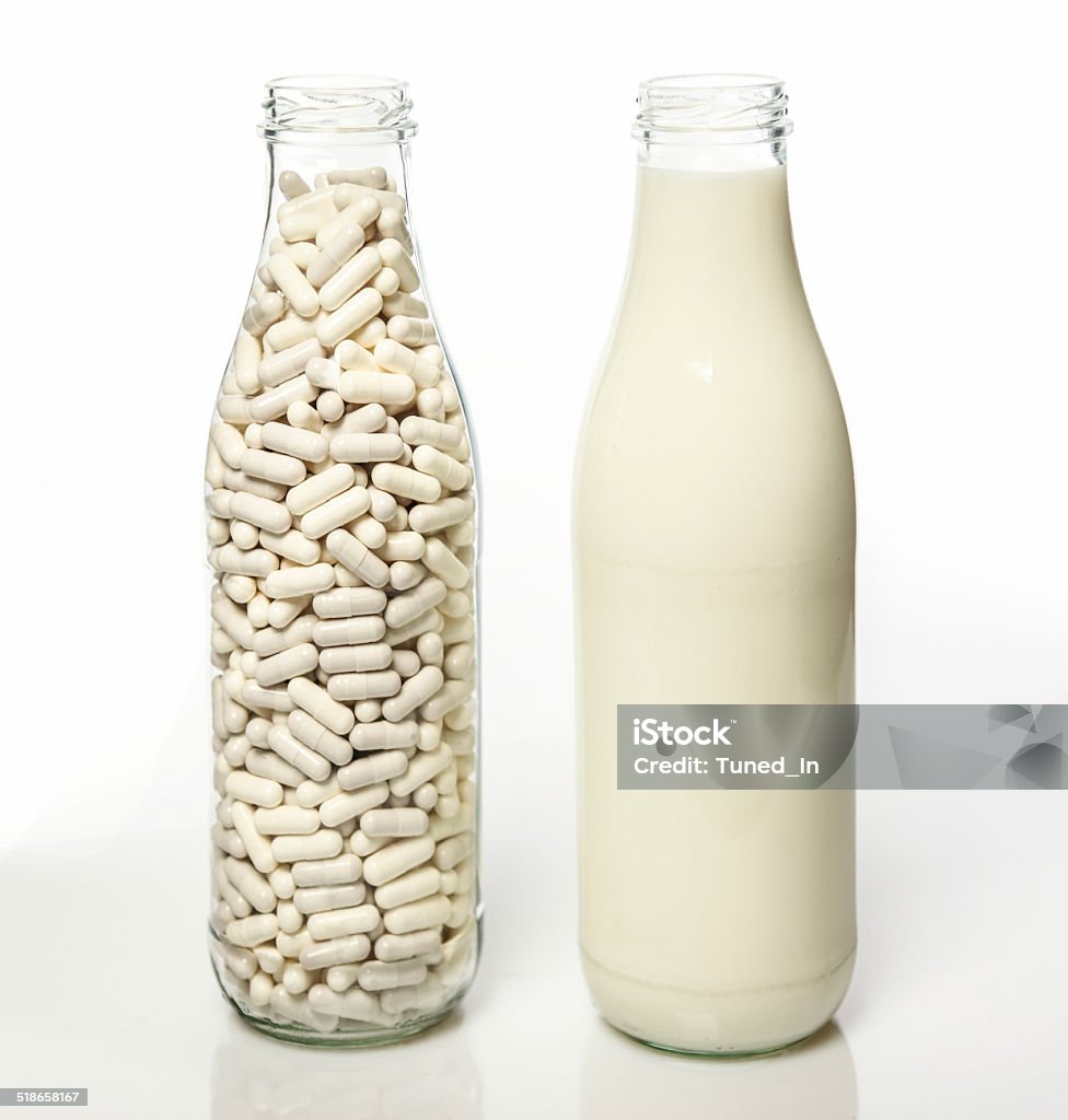 Two milk bottles one filled with milk Two milk bottles one filled with milk the other filled with lactase pills Lactose Fermentation Stock Photo