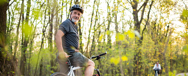 homme senior sur son vélo de montagne en plein air - cycling senior adult sports helmet men photos et images de collection