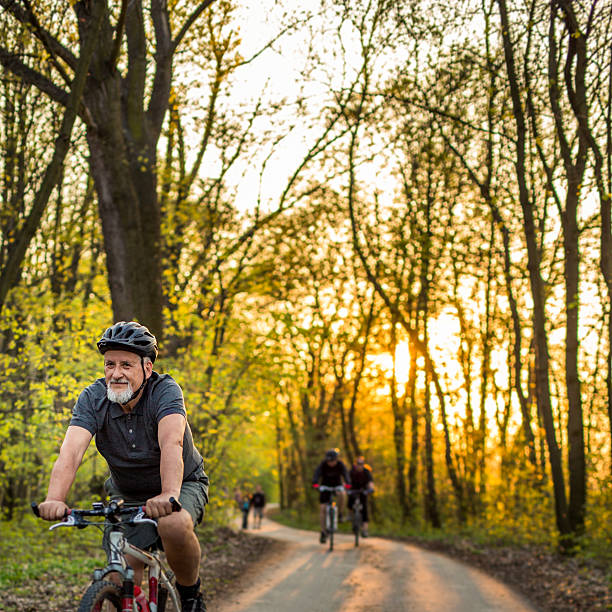 homme senior sur son vélo de montagne en plein air - cycling senior adult sports helmet men photos et images de collection