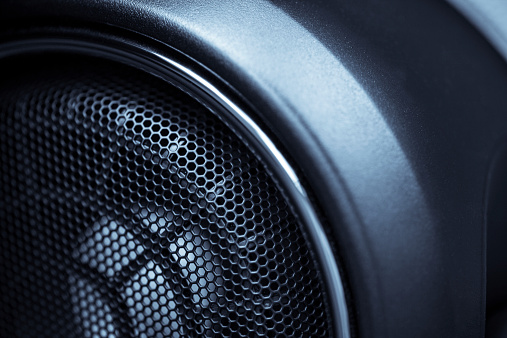 Close up shot of a round speaker in a car.