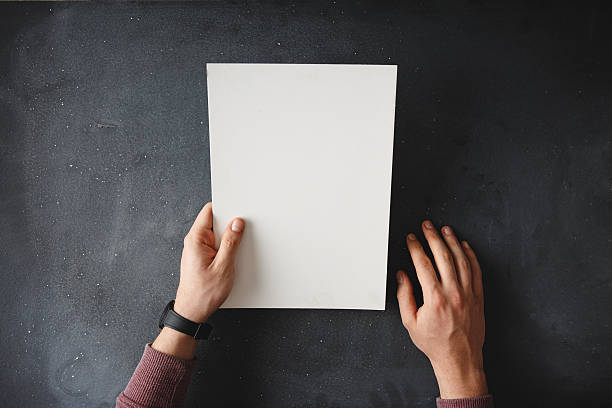 istock Hand holding blank brochure on black table 518673966