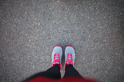 Woman sport shoe on asphalt aerial view.