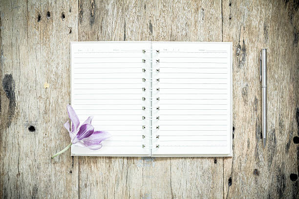 istock Open Notebook and pen on old wooden background. 518675940