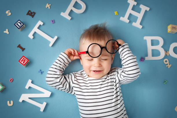 istock One year old child lying with spectacles and letters 518676898