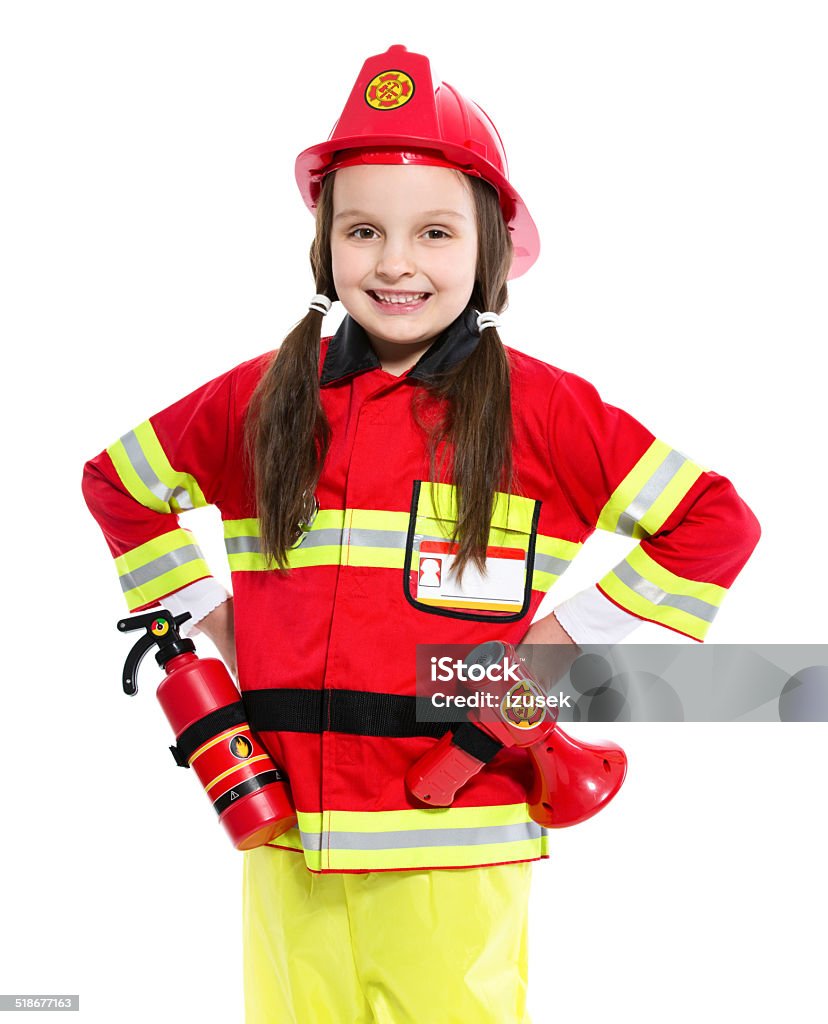 Young Female Firefighter Portrait of little girl dressed as a firefighter standing with hands on hips and smiling at the camera. Studio shot, isolated on white. Child Stock Photo