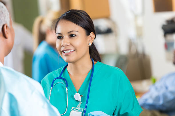 istock Friendly hospital nurse talking with colleague in crowded lab 518677419