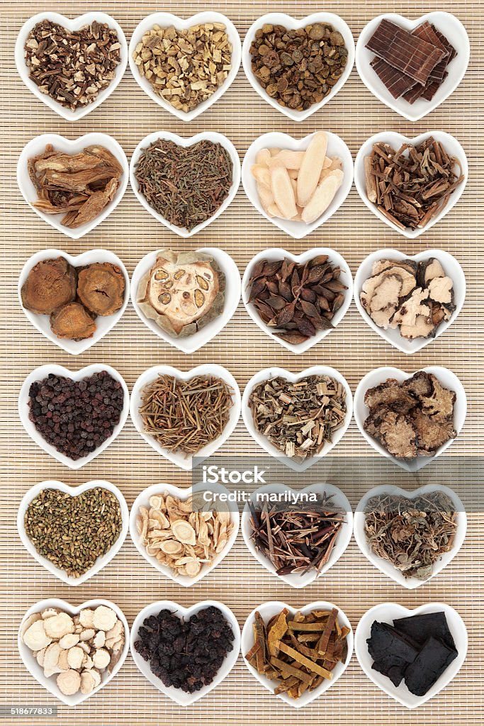Chinese Herbal Medicine Large chinese herbal medicine selection in heart shaped porcelain bowls over bamboo background. Alternative Medicine Stock Photo