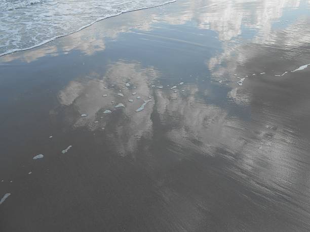 istock Clouds Reflecting in Wet Sand on Ocean Beach. 518679720