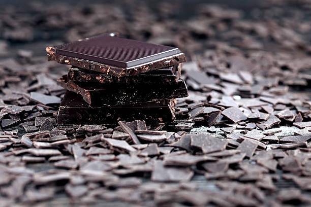 istock Broken dark chocolate and chocolate flakes on a wooden table 518679754