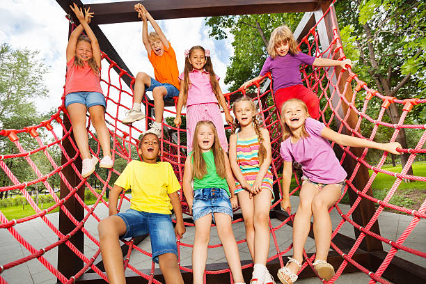 istock Excited kids playing together on net ropes 518680673