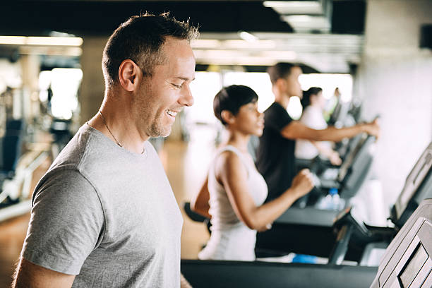 多様な人々のトレッドミルでランニング - treadmill gym health club exercising ストックフォトと画像