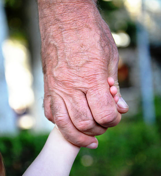istock Grandpa hold baby hand 518681906