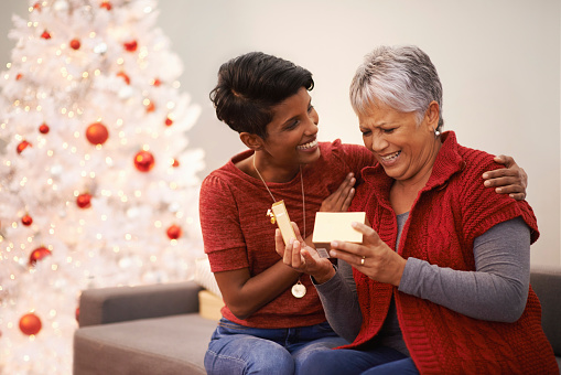 A senior woman receiving a present from her daughter on Christmas