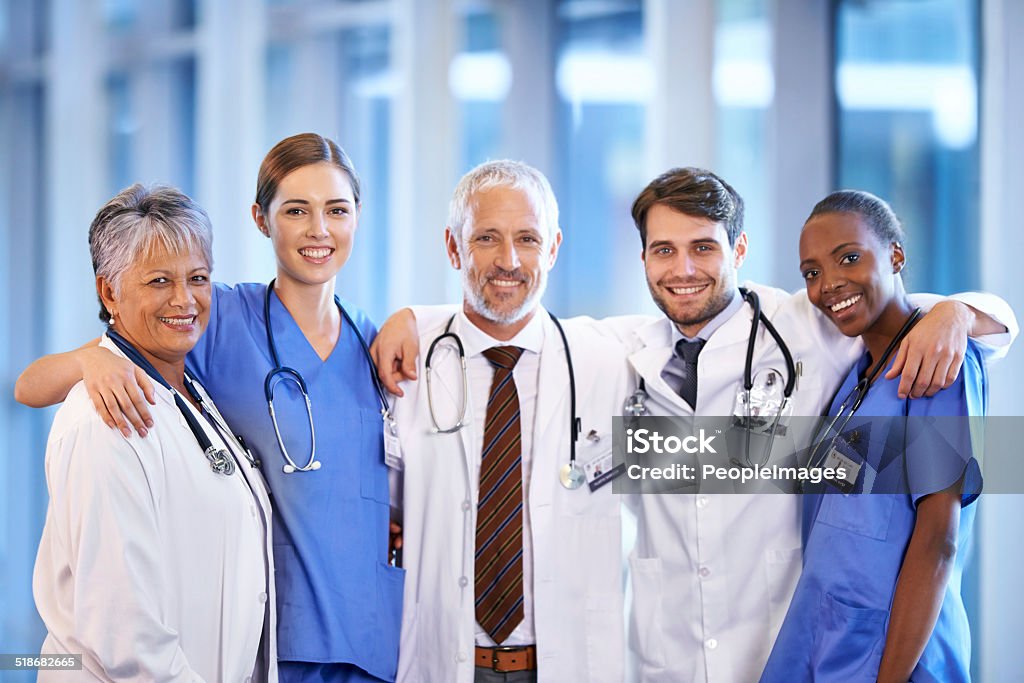 Staying positive as a team Portrait of a happy healthcare team Arm Around Stock Photo