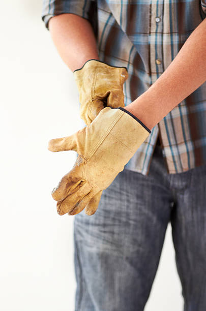 Getting ready for handywork Cropped image of a handyman putting on gloves handywork stock pictures, royalty-free photos & images