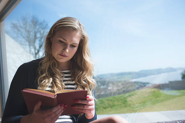 istock Beautiful young woman reading 518683944