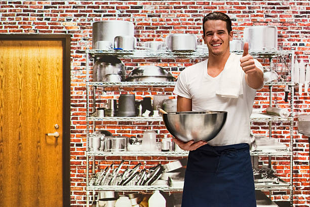 istock Smiling chef showing thumbs up in kitchen 518685770
