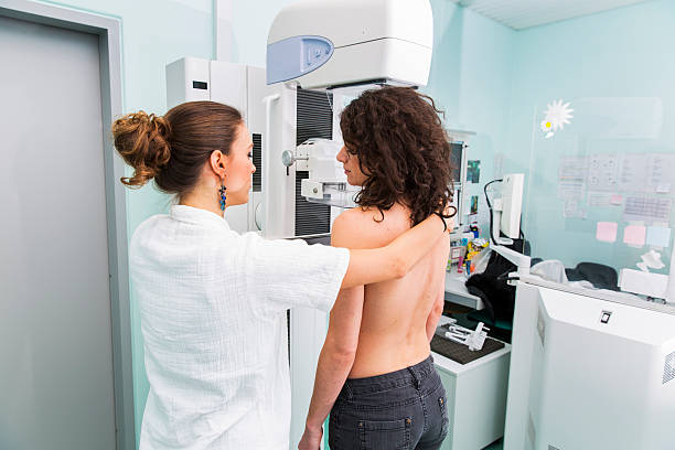 Nurse with young women having a mammography Nurse with young women having a mammography x ray image medical occupation technician nurse stock pictures, royalty-free photos & images