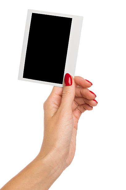 istock Woman's Hand Holding Polarid Photo 518686882