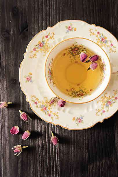 istock Vintage cup of tea with rosebuds, on black background 518687286