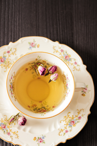 Vintage cup of tea with buds of roses, fragrant breakfast aristocracy