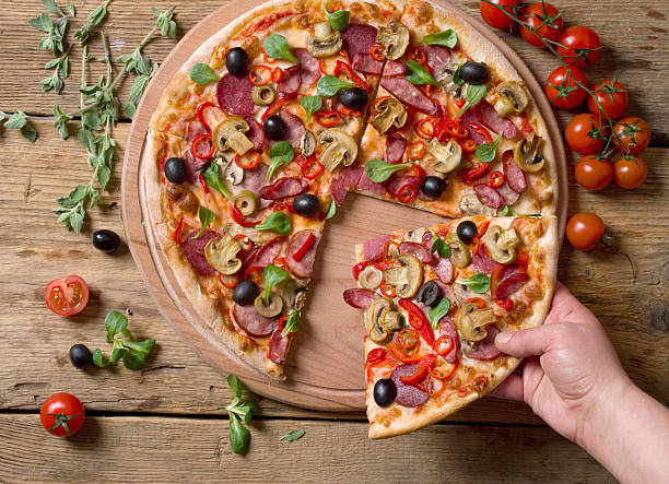 istock hand taking slices of pizza 518687580
