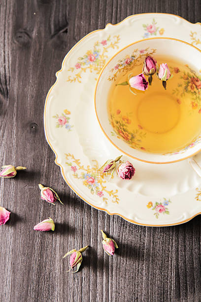 istock Vintage cup of tea with rosebuds, on black background 518687658