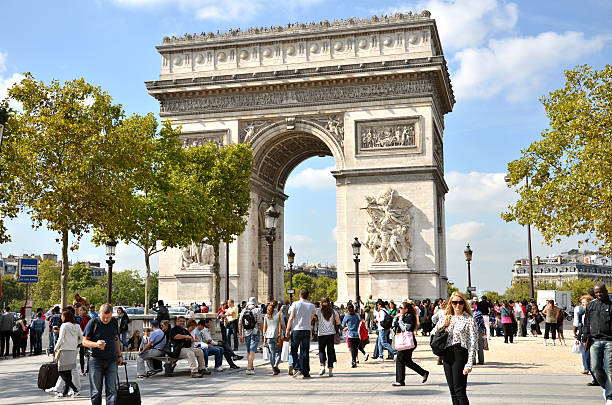 People near the famous monument "The Arc de Triomphe" Paris, France - September 23, 2011: Many people at the western end of the Avenue des Champs-Elysees with very famous monument "The Arc de Triomphe" in background arc de triomphe paris stock pictures, royalty-free photos & images