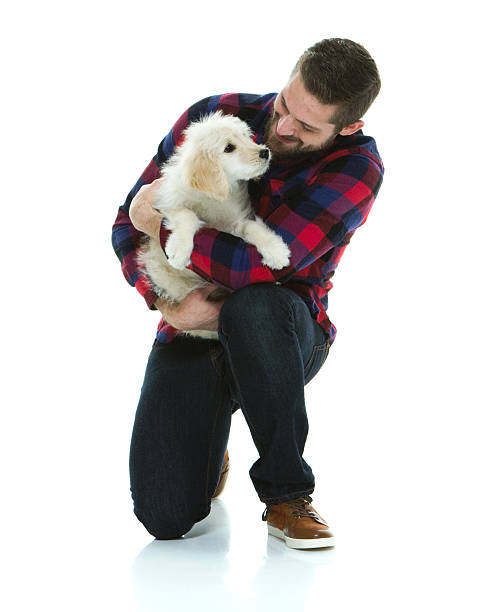 istock Smiling man cuddling with dog 518702690