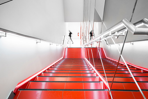 Bright red, white and chrome fire escape with ghosting figure.
