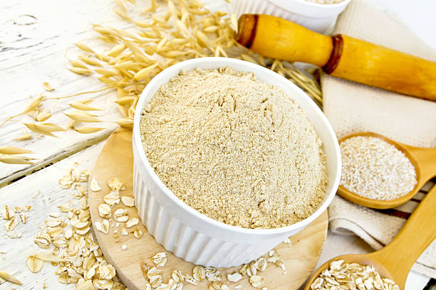 istock Flour oat in white bowl with flakes on light board 518704082