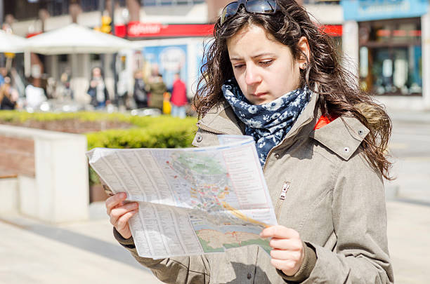 istock Young beautiful female tourist with map looking for the directio 518704736