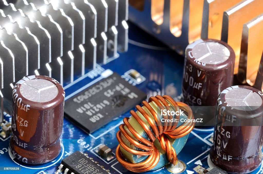 Close-up of inductors, capacitors, cooler and chips Detail of graphics card - inductors, cooler, capacitors and chips Mother Board Stock Photo