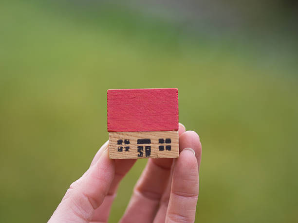 istock Hand with miniature house in the countryside 518706864