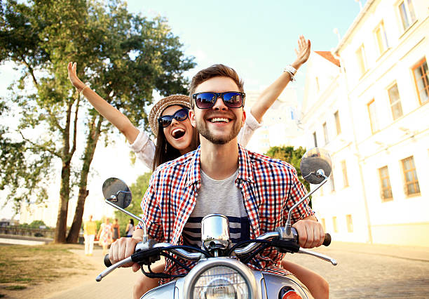 retrato de joven feliz pareja disfrutando de vespa viaje - joven moto fotografías e imágenes de stock