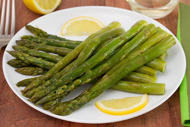istock fried asparagus with lemon on the plate 518717661